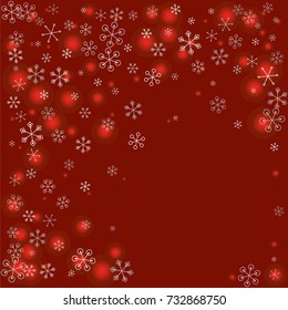 Christmas background with random scatter falling silver snowflakes and red blurred lights on a burgundy background.