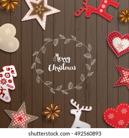 Christmas background, small scandinavian styled red decorations lying on brown wooden desk, inspired by flat lay style, with text Merry christmas, framed by abstract leaf wreath, vector illustration