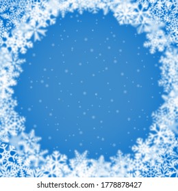 Christmas background of snowflakes of different shape, blur and transparency, arranged in a circle, on light blue background