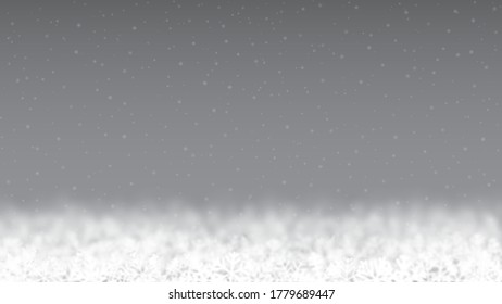 Weihnachtshintergrund von Schneeflocken verschiedener Form, unscharf und transparent, unten auf grauem Hintergrund