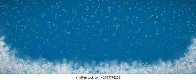 Christmas background of snowflakes of different shapes, sizes, blur and transparency on blue background