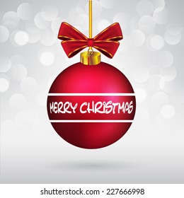 Christmas ball with bow and Merry Christmas text on sparkling background.