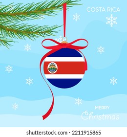 Christmas ball with the Costa Rica flag, decorates the Christmas tree branch. Illustration of a Christmas ball with the flag of Costa Rica in a Christmas tree branch on a winter background