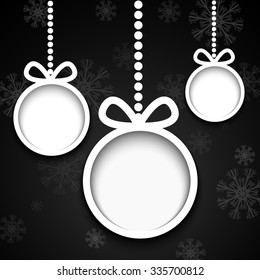 Christmas balls cut from paper on black background with snowflakes.