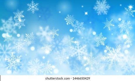 Christmas blurred background of complex defocused big and small falling snowflakes in light blue colors with bokeh effect