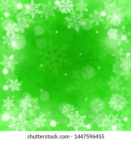 Christmas blurred background of complex defocused big and small falling snowflakes in green colors with bokeh effect