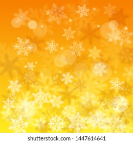 Christmas blurred background of complex defocused big and small falling snowflakes in yellow colors with bokeh effect