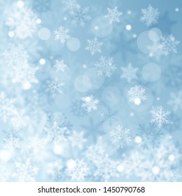 Christmas blurred background of complex defocused big and small falling snowflakes in light blue colors with bokeh effect