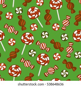 Christmas candy and candy canes on a green background. Seamless pattern.