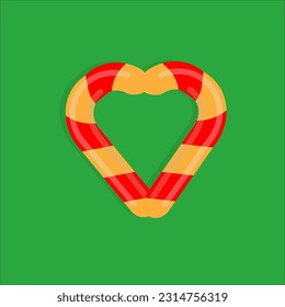 Christmas candy on a green background in the form of a heart