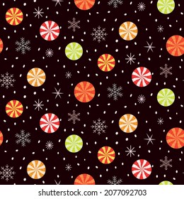 Christmas candy peppermint seamless pattern in yellow, orange, red, and green with snowflakes and stars on dark background. Great for greeting cards , gift wrapping paper and textile