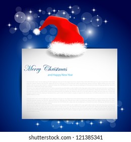 christmas cap with blank of paper on blue background