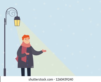 Christmas card. A boy near a glowing lantern catches snowflakes
