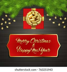 Christmas card with Cristmas fir tree branches, red square gift box with gold ribbon bow, garland on black wooden board. Greeting text Merry Chrismas and Happy New Year on red label with gold frame