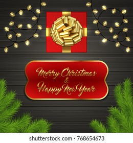 Christmas card with Cristmas fir tree branches, red square gift box with gold ribbon bow, garland on black wooden board. Greeting text Merry Chrismas and Happy New Year on red label with gold frame