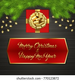 Christmas card with Cristmas fir tree branches, red square gift box with gold ribbon bow, garland on black wooden board. Greeting text Merry Chrismas and Happy New Year on red label with gold frame