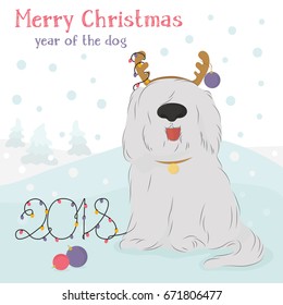 Christmas card with large, shaggy dog breed Bobtail with decorative reindeer and Christmas balls on a blue background with snow.