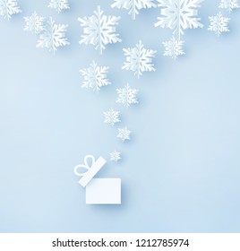 Christmas card with paper snow flakes. Open gift box and flying snowflakes on blue background. Vector xmas, New Year or winter concept.
