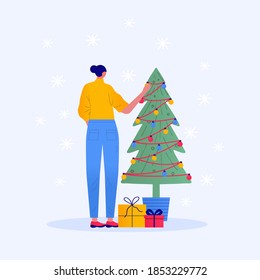 Christmas character decoration. Young beautiful woman decorate Christmas tree. Gifts under christmas tree