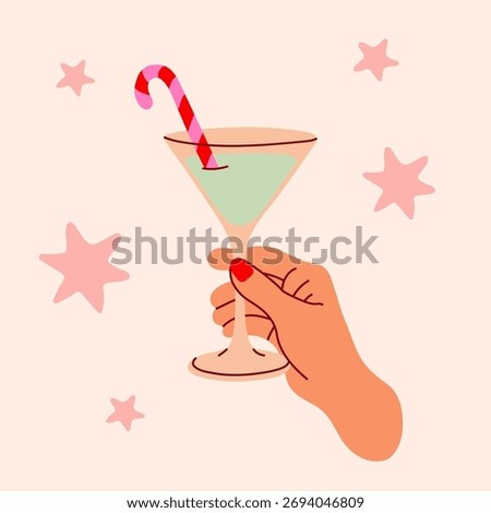 Christmas cocktail with candy cane stirrer held by hand