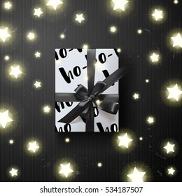 Christmas Color vector gift box with ho-ho-ho on the package . Glowing star Lights   