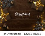 Christmas composition on wooden background. Xmas decoration design, box gift, snowflake color black, gold light garland, pine cone. Brown realistic wood texture. Flat lay, top view.