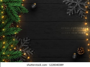 Christmas composition on wooden background. Xmas decoration design, bauble ball, snowflake color black, gold light garland, pine cone, fir branches. Balck realistic Wood texture. Flat lay, top view.