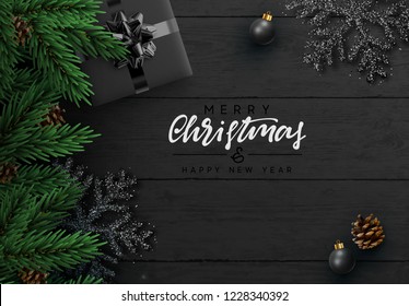 Christmas composition on wooden background. Xmas decoration design, bauble ball, snowflake color black, pine cone, green fir branches. Black realistic Wood texture. Flat lay, top view.