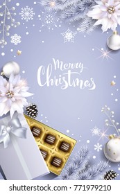 Christmas composition with white balls,poinsettia and  box of chocolates