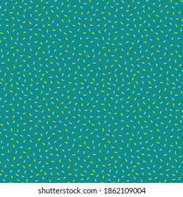Christmas confetti sprinkles seamless pattern in shades of green. Teal, pastel blue, emerald and pistachio green non-directional confetti backdrop. Classic holiday abstract background, wrapping paper.