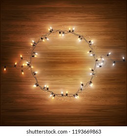 Christmas decorative realistic garland with shiny  glowing lights, round frame on wooden background, vector illustration