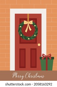 Christmas door decorated by a wreath with a gift box next to it and a "Merry Christmas" text. Vector flat illustration. Winter holiday season. Christmas greeting card template.