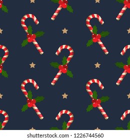 Christmas elements seamless pattern of candy canes with holly leaves and berries branches ornate and stars on dark blue color background. Design for winter holidays greeting season wrapping papers etc