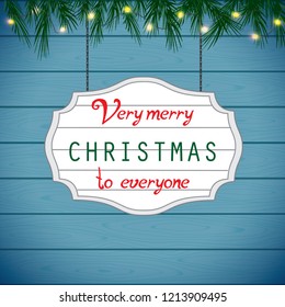 Christmas festive wooden background with fir branches and light garland