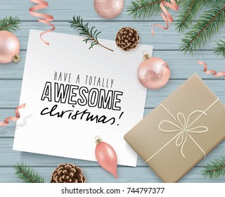 Christmas flat lay design with gift box, ribbons, Christmas ornaments, pine cones, fir branches and greeting card on wooden background