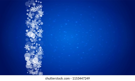 Christmas frame with falling snow on blue background with sparkles. Horizontal Christmas frame with white frosty snowflakes for banners, gift cards, party invitations and special business offers.
