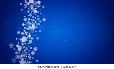 Christmas frame with falling snow on blue background with sparkles. Horizontal Christmas frame with white frosty snowflakes for banners, gift cards, party invitations and special business offers.