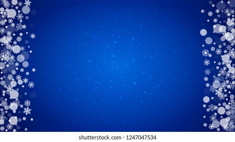 Christmas frame with falling snow on blue background with sparkles. Horizontal Christmas frame with white frosty snowflakes for banners, gift cards, party invitations and special business offers.