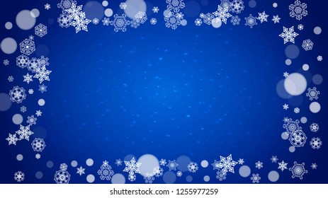 Christmas frame with falling snow on blue background with sparkles. Horizontal Christmas frame with white frosty snowflakes for banners, gift cards, party invitations and special business offers.