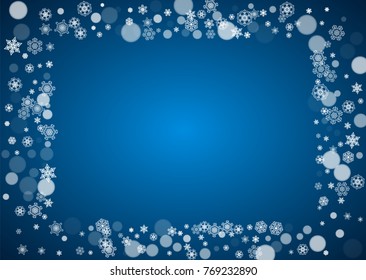 Christmas frame with falling snow on blue background. Horizontal Merry Christmas frame with white frosty snowflakes for banners, gift cards, party invitations and special business offers.