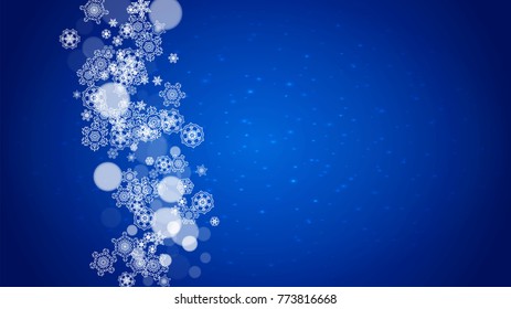Christmas frame with falling snow on blue background with sparkles. Horizontal Christmas frame with white frosty snowflakes for banners, gift cards, party invitations and special business offers.