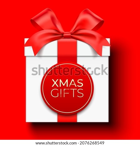 Christmas gifts vector card design, with white gift box wrapped with satin ribbon, and lettering label, lying on red background with copy space.