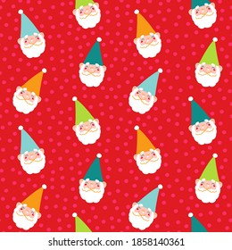 Christmas gnomes faces in colorful hats on red confetti polka dot background. Winter holiday seamless pattern for wrapping paper, festive backdrops and decoration.