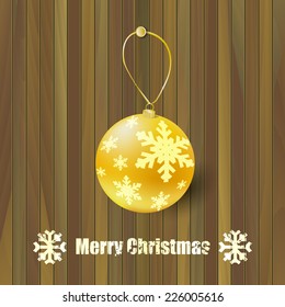 Christmas golden ball on wooden background. Christmas card. Wooden texture. 