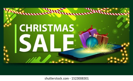 Christmas green discount banner with smartphone from the screen which appear gifts