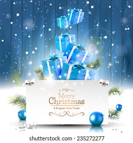 Christmas greeting card with blue gift boxes in the snow and with place for your text