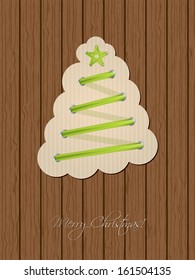 Christmas greeting card design with green shoe lace  tree and wooden background
