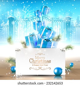 Christmas greeting card with gift boxes and paper in front of the winter landscape