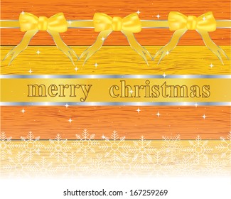 Christmas greeting card with gold ribbon on the wooden background