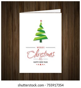 Christmas Greeting Card. Wooden background with painted holiday typography and Christmas tree.